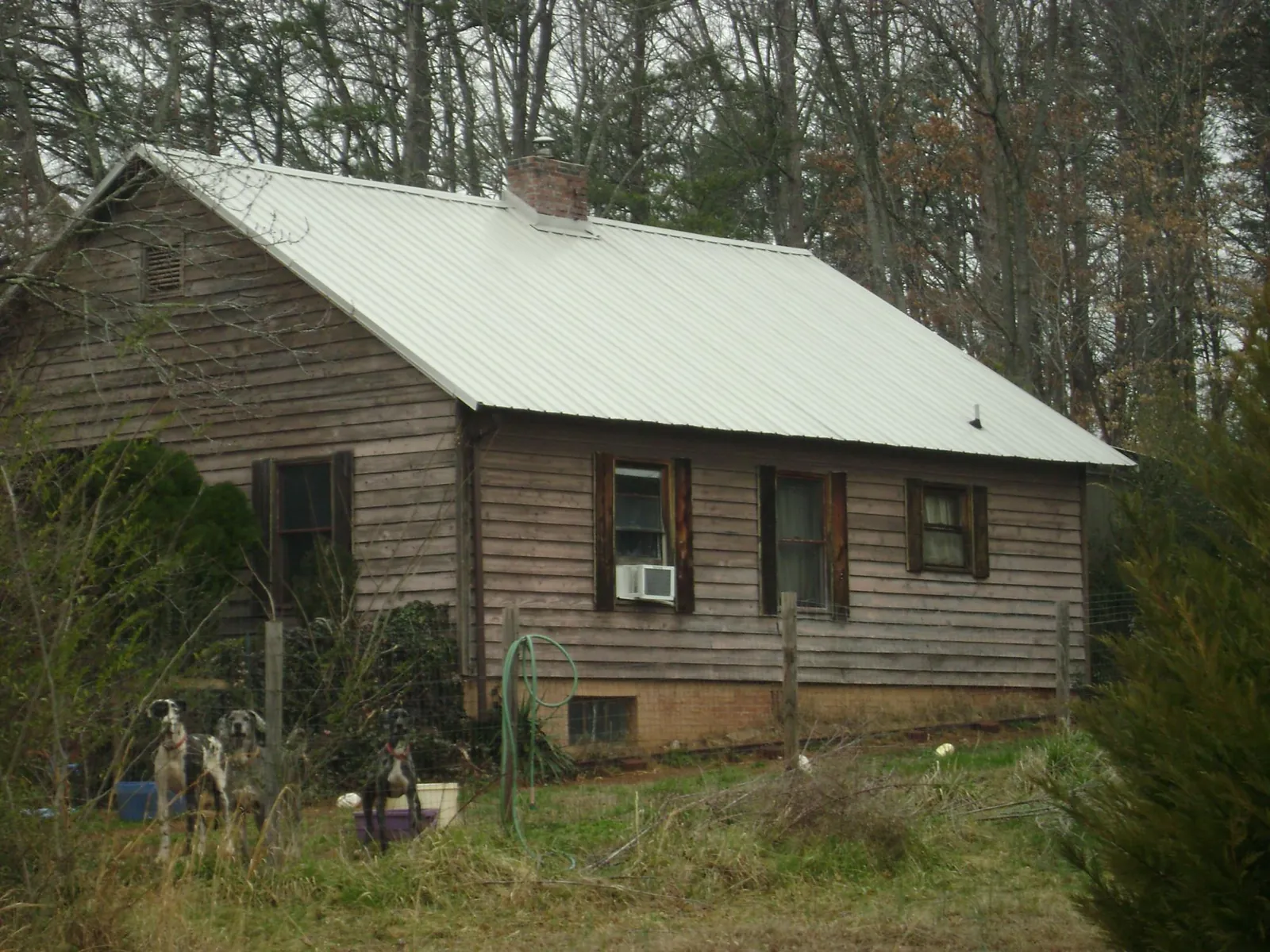 White metal roof on an old wood sided farmhouse, from a Metal Roof Installation job in Harrisonville